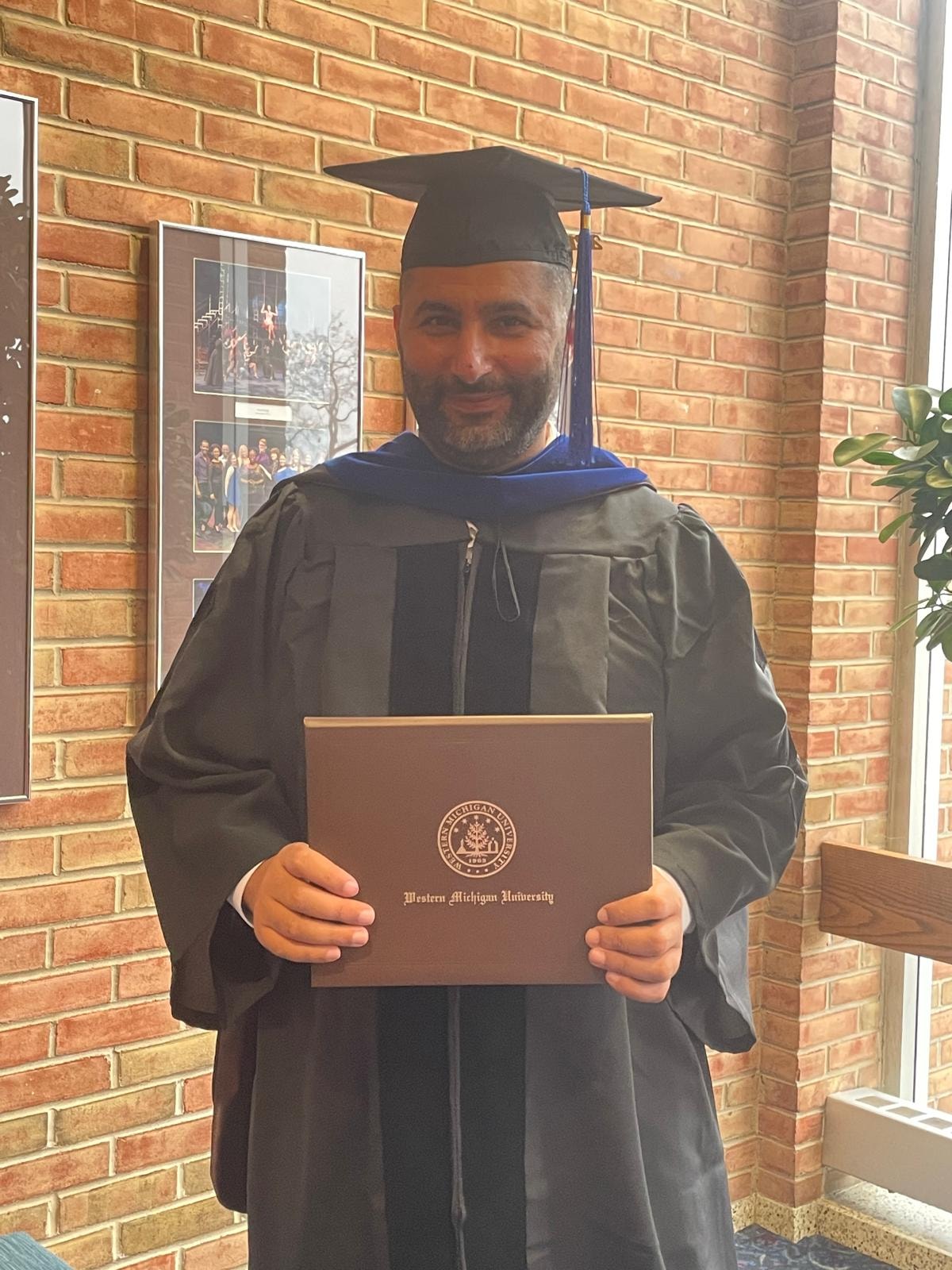 Dr. Jaafar Hachem in doctoral regalia holding diploma